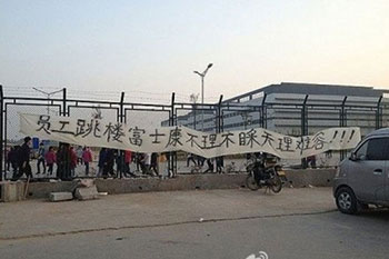 The parents of the first deceased worker tied a banner near the Foxconn gate.