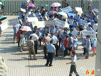 Workers from Shenzhen Asiacorp Electronics holding signs